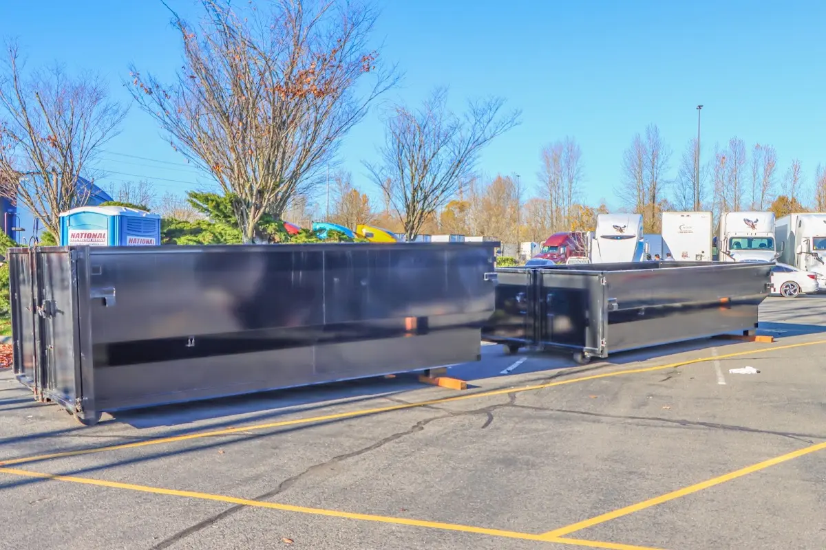 Professional dumpster rental service with roll-off container on residential driveway in Plymouth